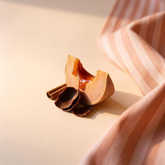 Ambiance d'automne : bâtons de cannelle, courge caramélisée et cacao sur un linge rayé pêche